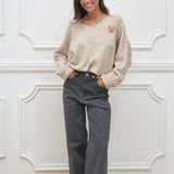 BEIGER PULLOVER MIT V-AUSSCHNITT „HERZ LEO"